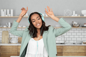 A woman wearing headphones in the kitchen