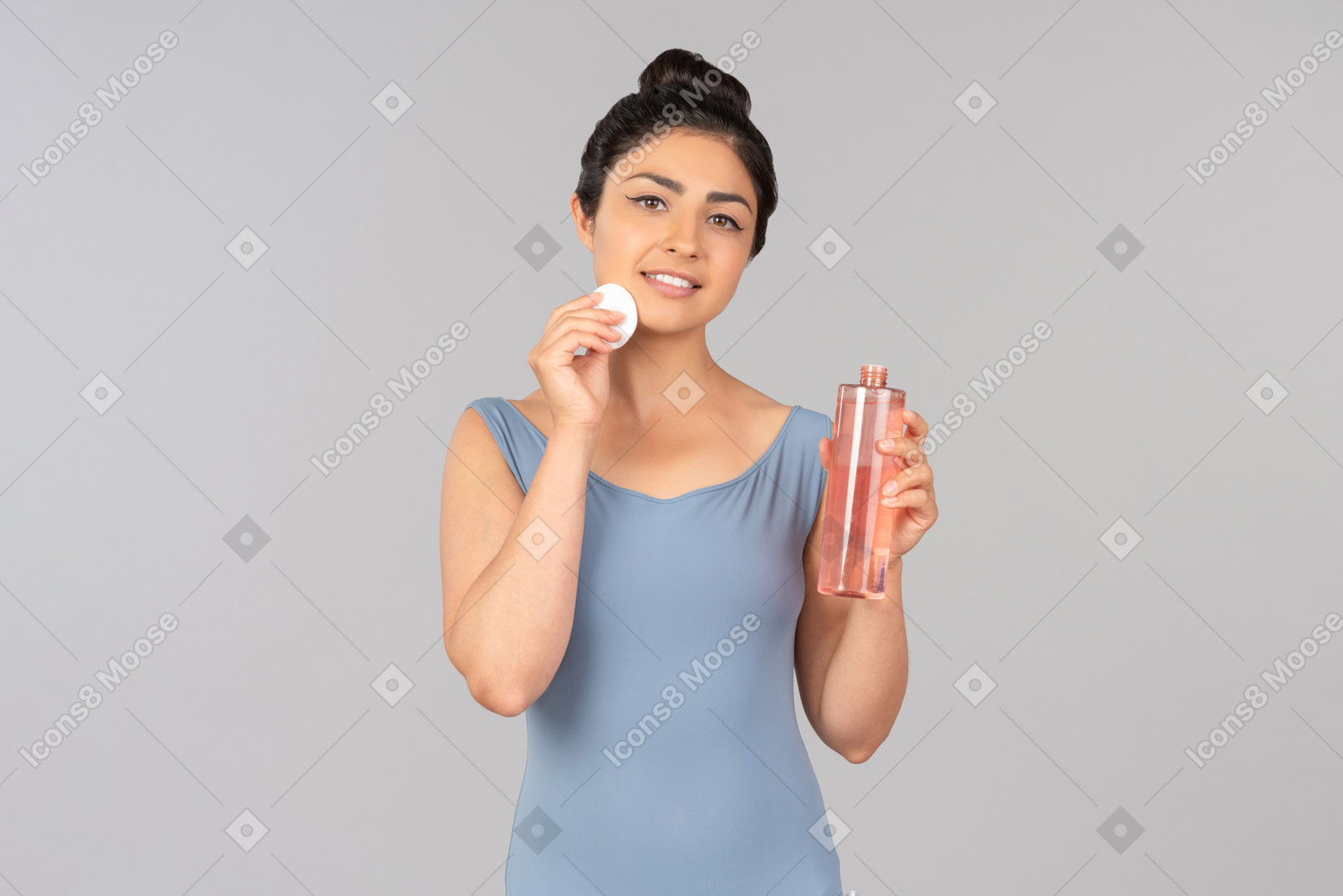 Young indian woman holding cotton pad and cleaning product