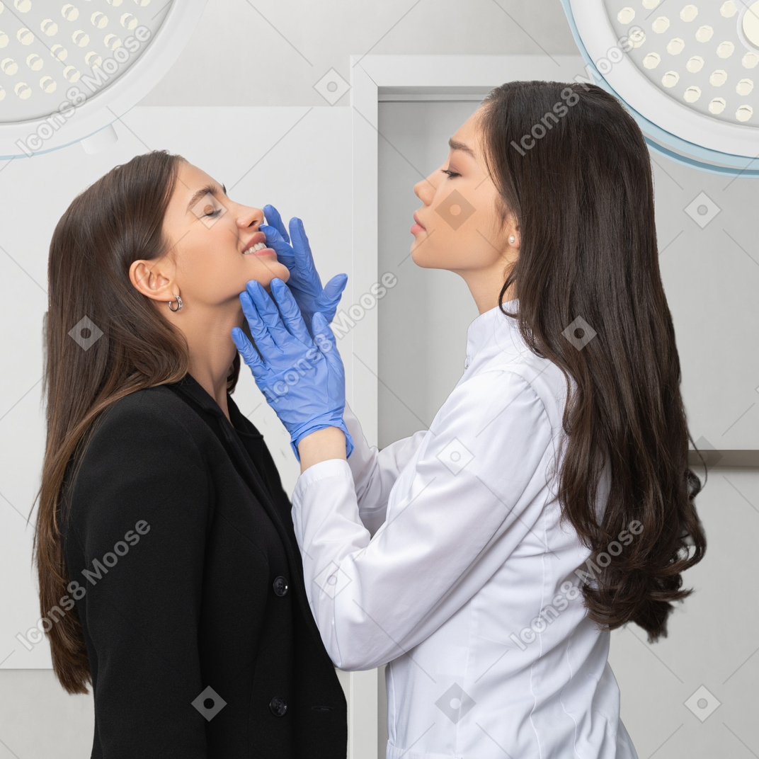 A female dentist checking female patient's teeth