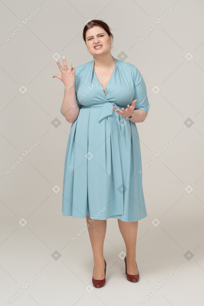 一个穿着蓝色连衣裙的女人做鬼脸的前视图