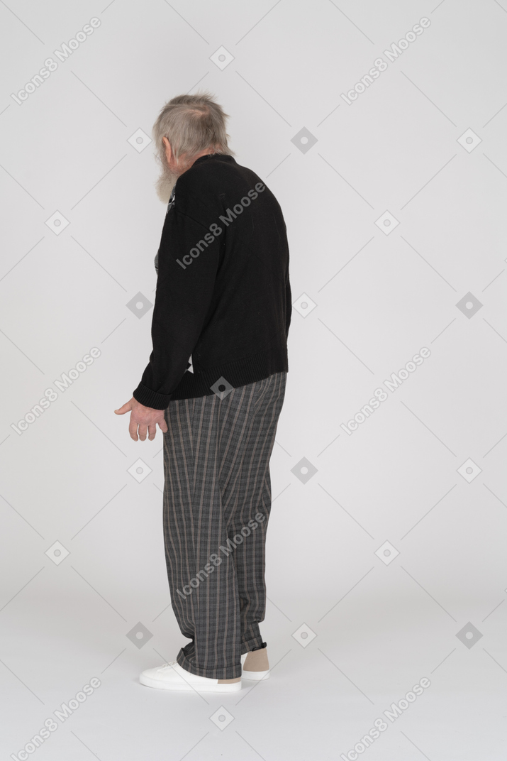Uomo anziano in piedi con la schiena rivolta verso la telecamera