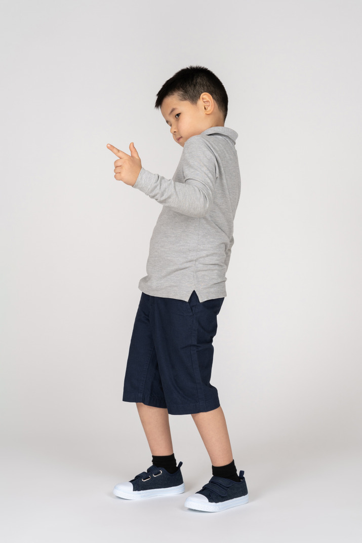 Side view of a boy pointing at something