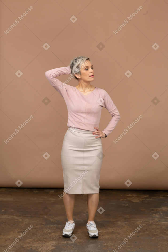 一个身着休闲服、手放在头后摆姿势的女人的前视图
