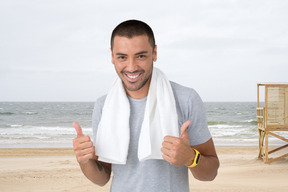 A man on the beach giving a thumbs up