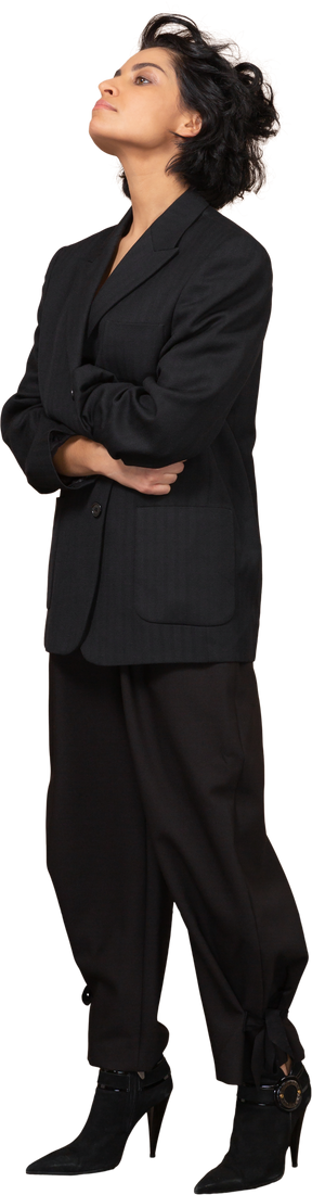 Vista de três quartos de uma mulher de negócios vestida de terno preto cruzando as mãos e jogando a cabeça para trás