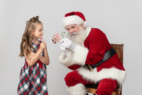 Niña niño escogió un bastón de caramelo de la cual la tenencia de santa