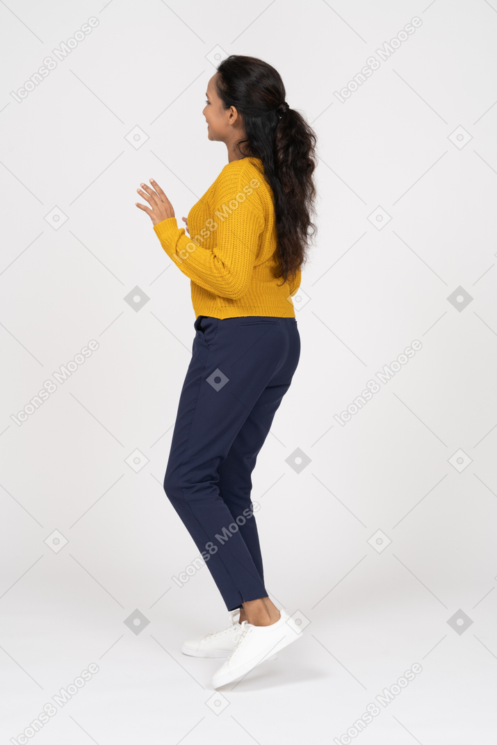 Rear view of a dancing girl in casual clothes