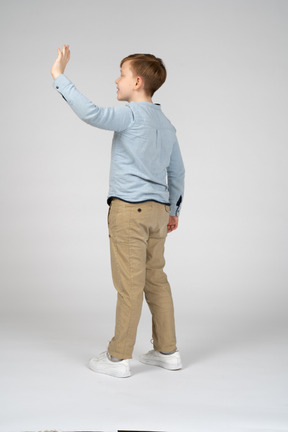 Back view of a boy waving