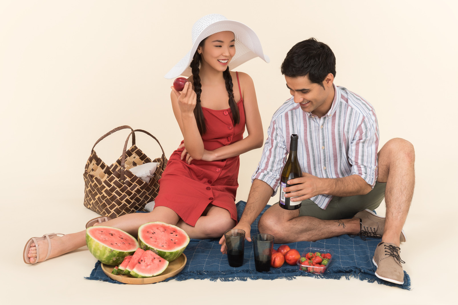 Young interracial couple having picnic and man pouring wine