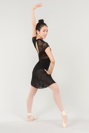 Joven bailarina asiática de pie en posición de ballet
