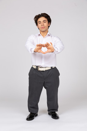 Young man making a heart shape with hands