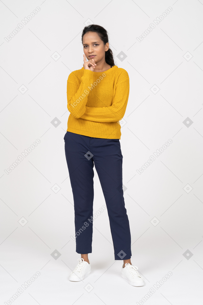 Front view of a thoughtul girl in casual clothes looking at camera