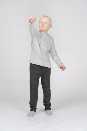 Vista frontal de um menino com punho no ar