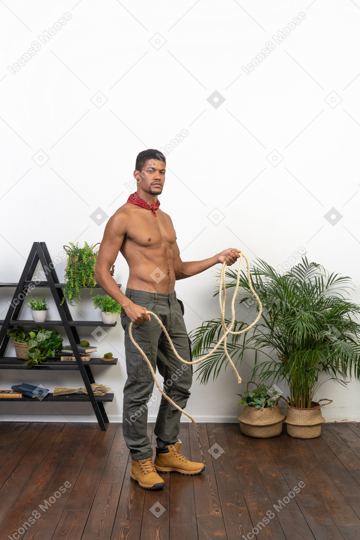 Standing muscular young man ready to throw a lasso