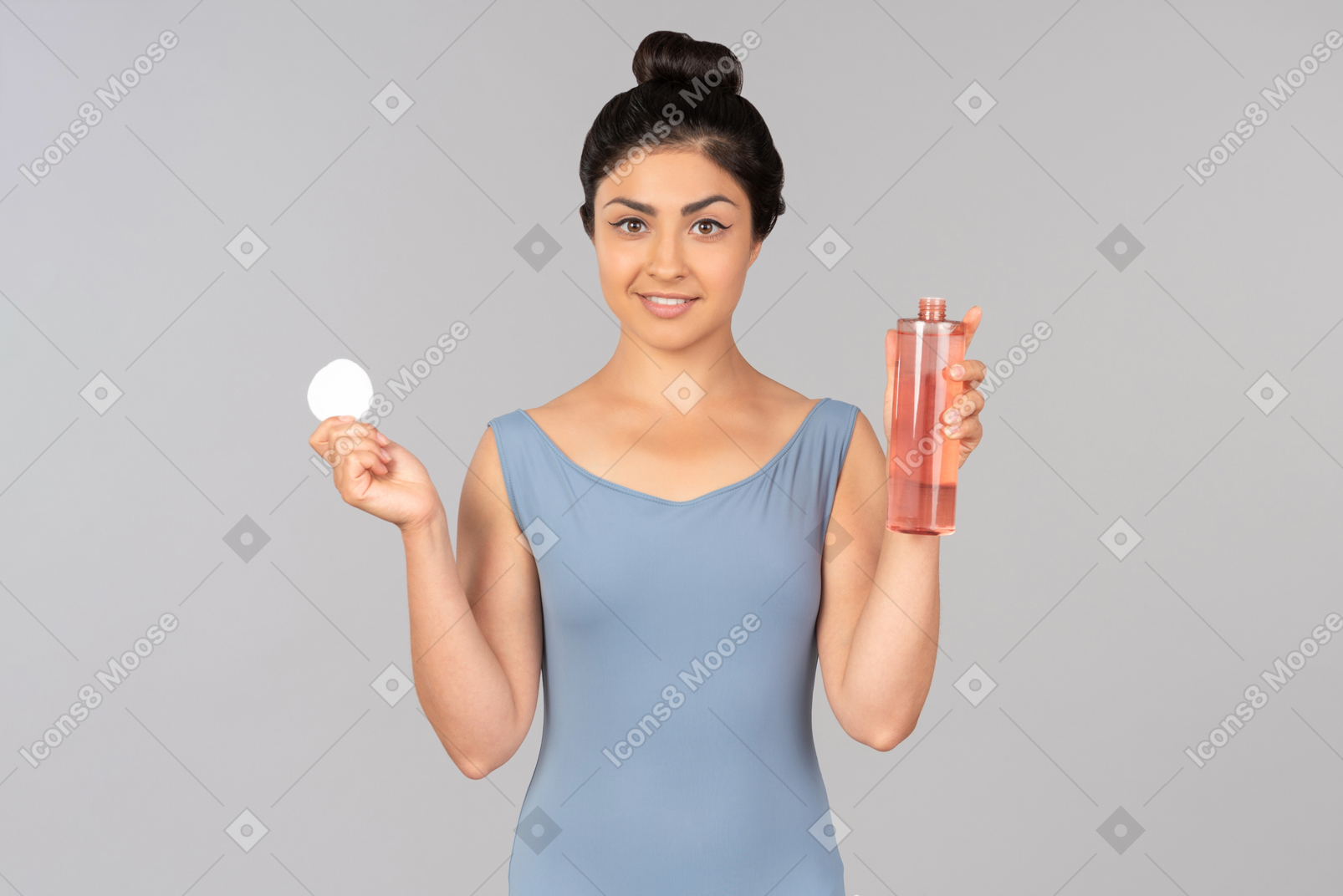 Young indian woman holding cotton pad and cleaning product
