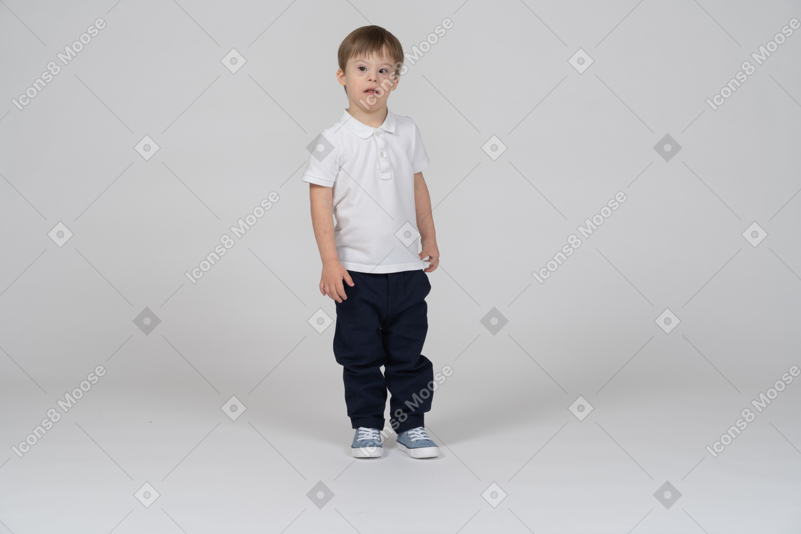 Вид спереди маленького мальчика, стоящего и смотрящего в сторону