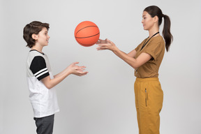Pe female teacher and pupil practicing basketball serves