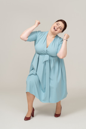 Front view of a happy woman in blue dress