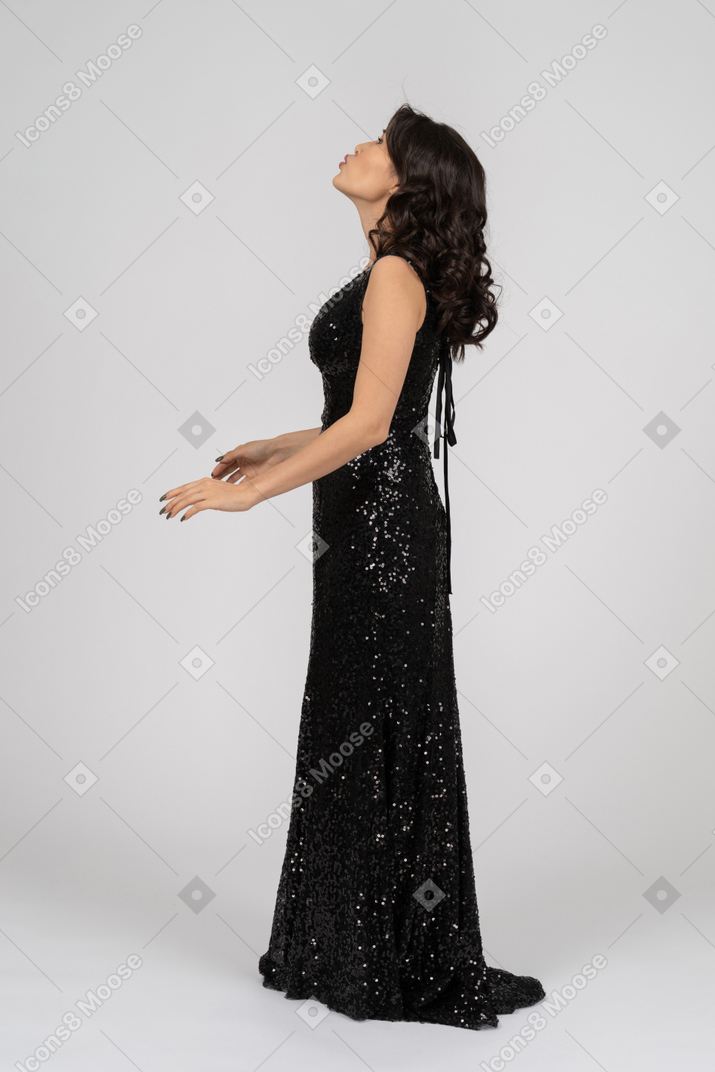 Woman in black evening dress talking to somebory above her