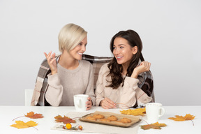 Junge frauen trinken kaffee und unterhalten sich