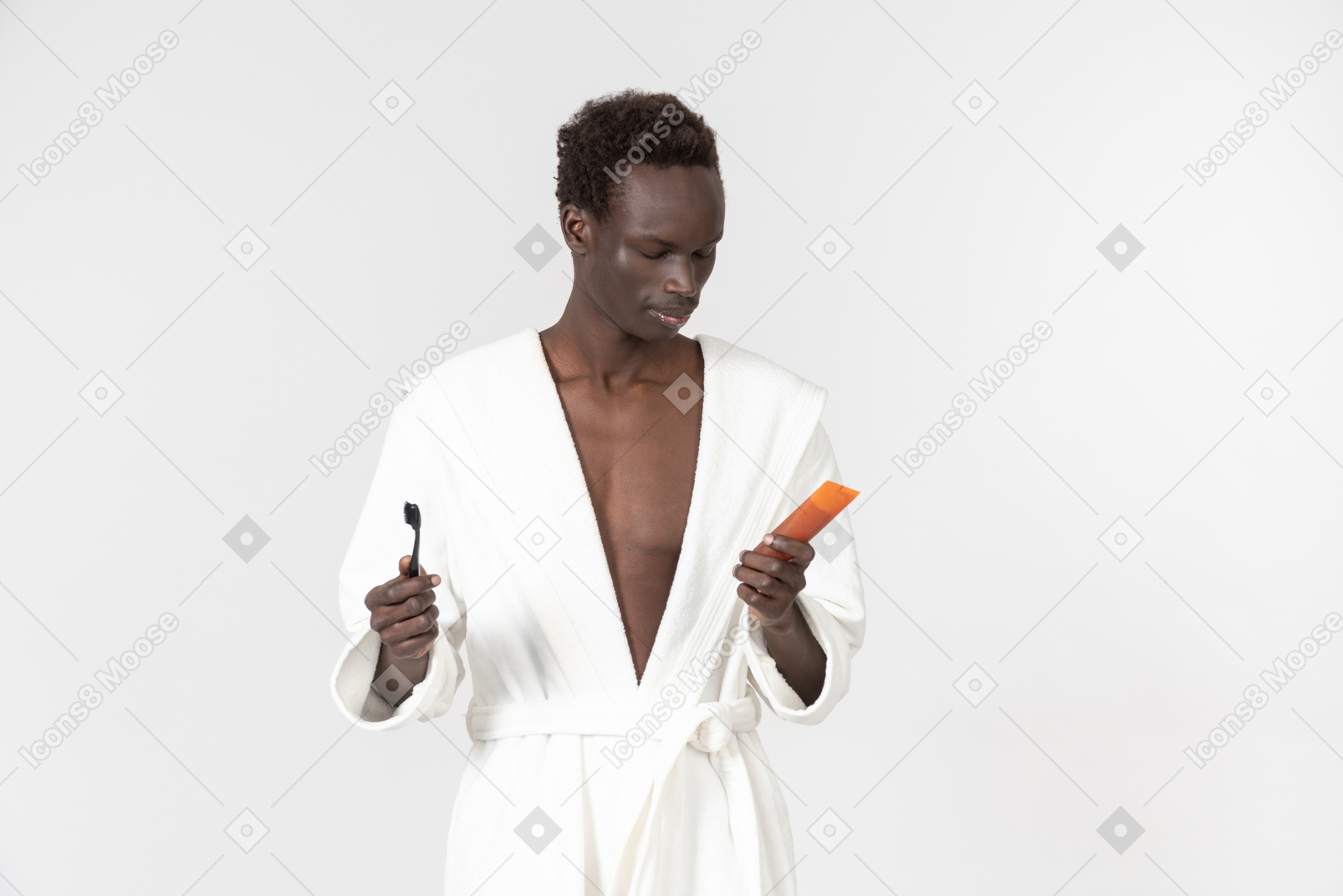 Jeune afroman tenant une brosse à dents et du dentifrice