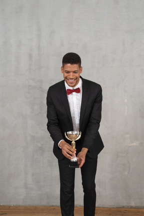 Hombre de traje entregando un premio a alguien pequeño