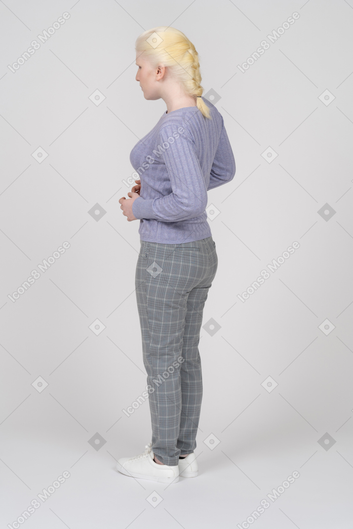 Rear view of young woman standing with arms bent