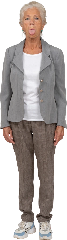 Vista frontal de una anciana en traje mirando a la cámara y mostrando la lengua