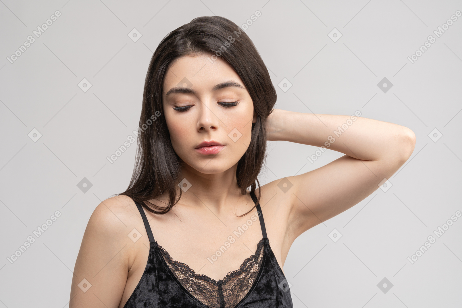 Young woman keeping eyes closed and touching her head