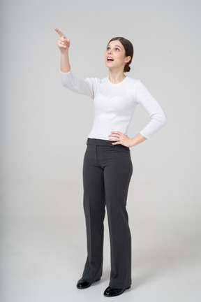 Front view of a woman in suit pointing with a finger