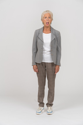 Вид спереди пожилой женщины, показывающей язык