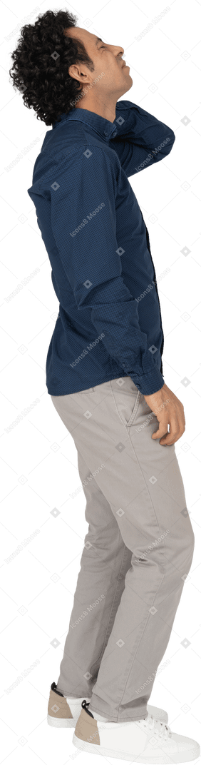 Vista lateral de um homem com roupas casuais sofrendo de dor no pescoço