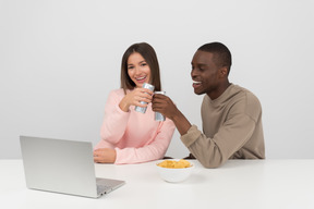 Casal atraente, assistindo a um jogo de esportes e bebendo cerveja