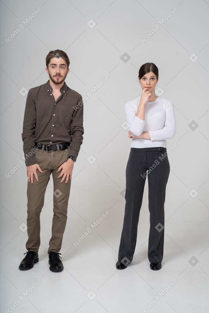 一对困惑的年轻夫妇穿着办公室服装的前视图