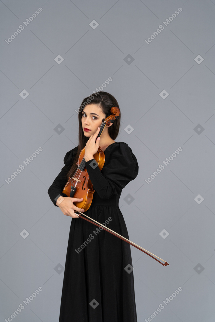 Close-up of a young lady in black dress holding the violin
