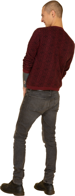 Back view of a young grimacing man in red sweater putting hands together