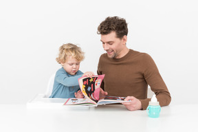 Padre e hijo leyendo un libro ilustrado