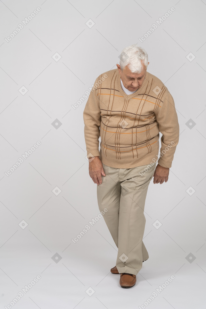 前方に歩いているカジュアルな服装の老人の正面図