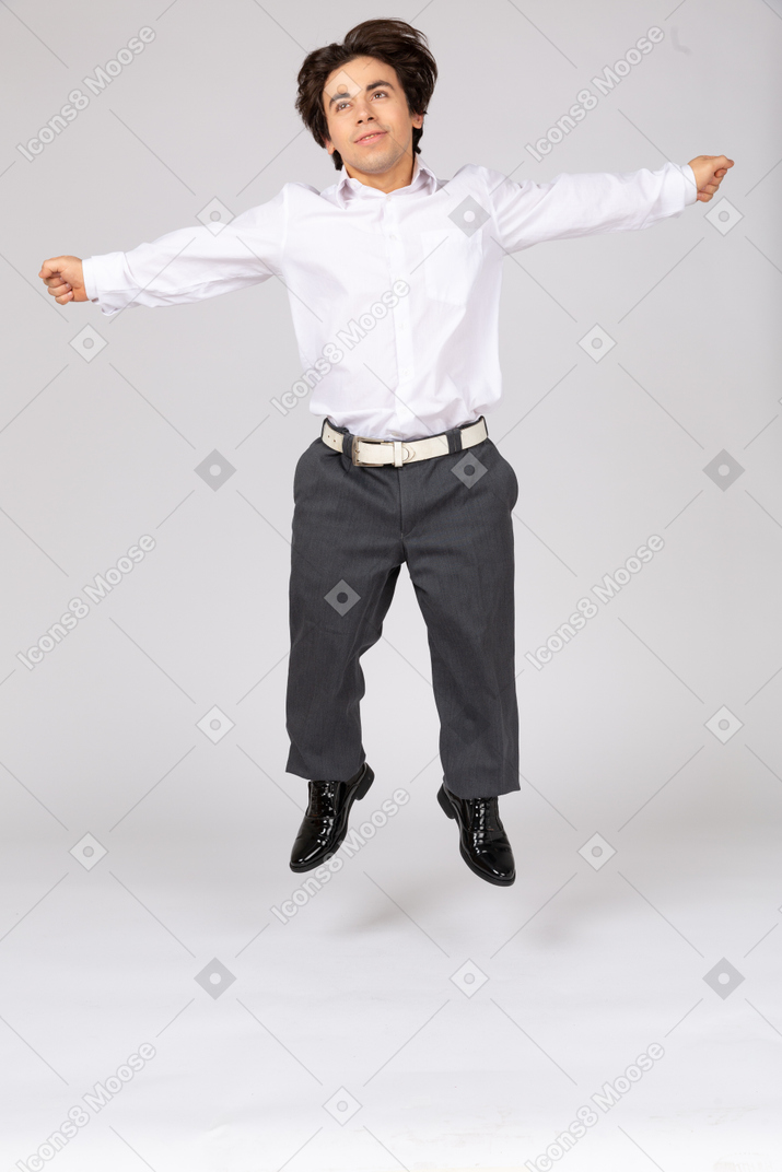 Homme heureux sautant avec les bras écartés
