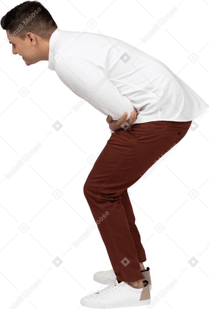 Vista lateral de un joven latino en cuclillas y riendo a carcajadas