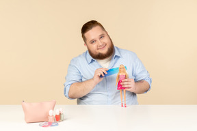 Big man holding hair brush and barbie doll