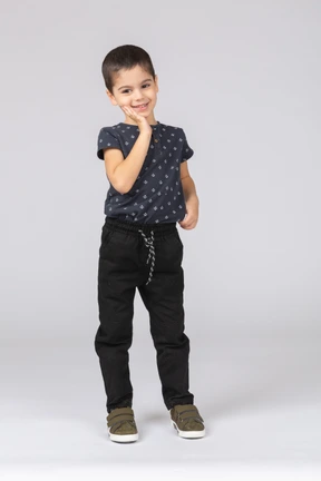 Front view of a cute boy posing with hand on cheek and looking at camera