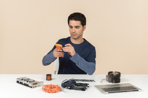 A young man in casual blue clothes working with computer details