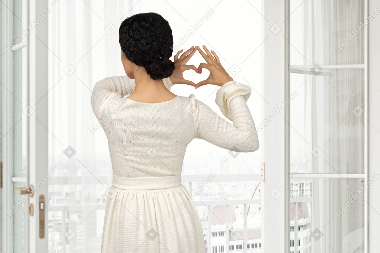 Mujer cerca de la ventana que muestra el corazón con las manos