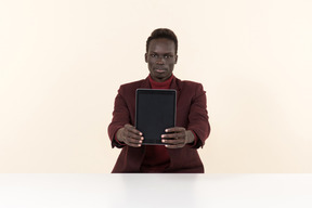 Elegante homem negro sentado à mesa no escritório