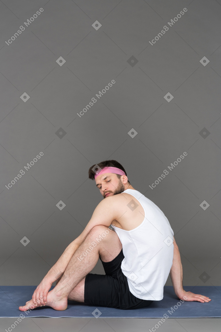Flexible young man doing side crunches