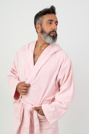 Man in pink robe looking aside