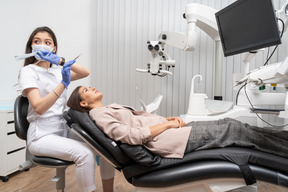 Full-length of a disturbed female dentist  and her patient with a mirror