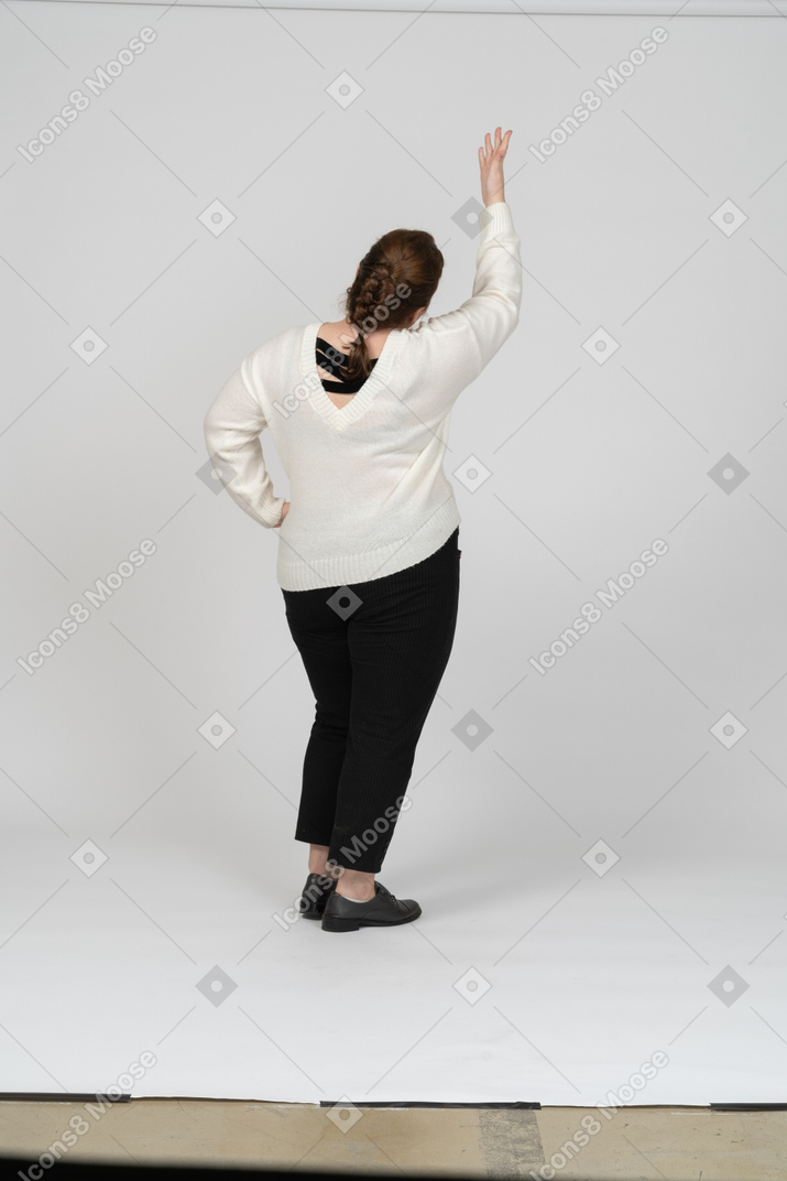 Vista posteriore di una donna plus size in abiti casual con la mano alzata
