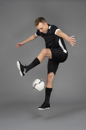Ein junger sportlicher mann, der einen ball jongliert